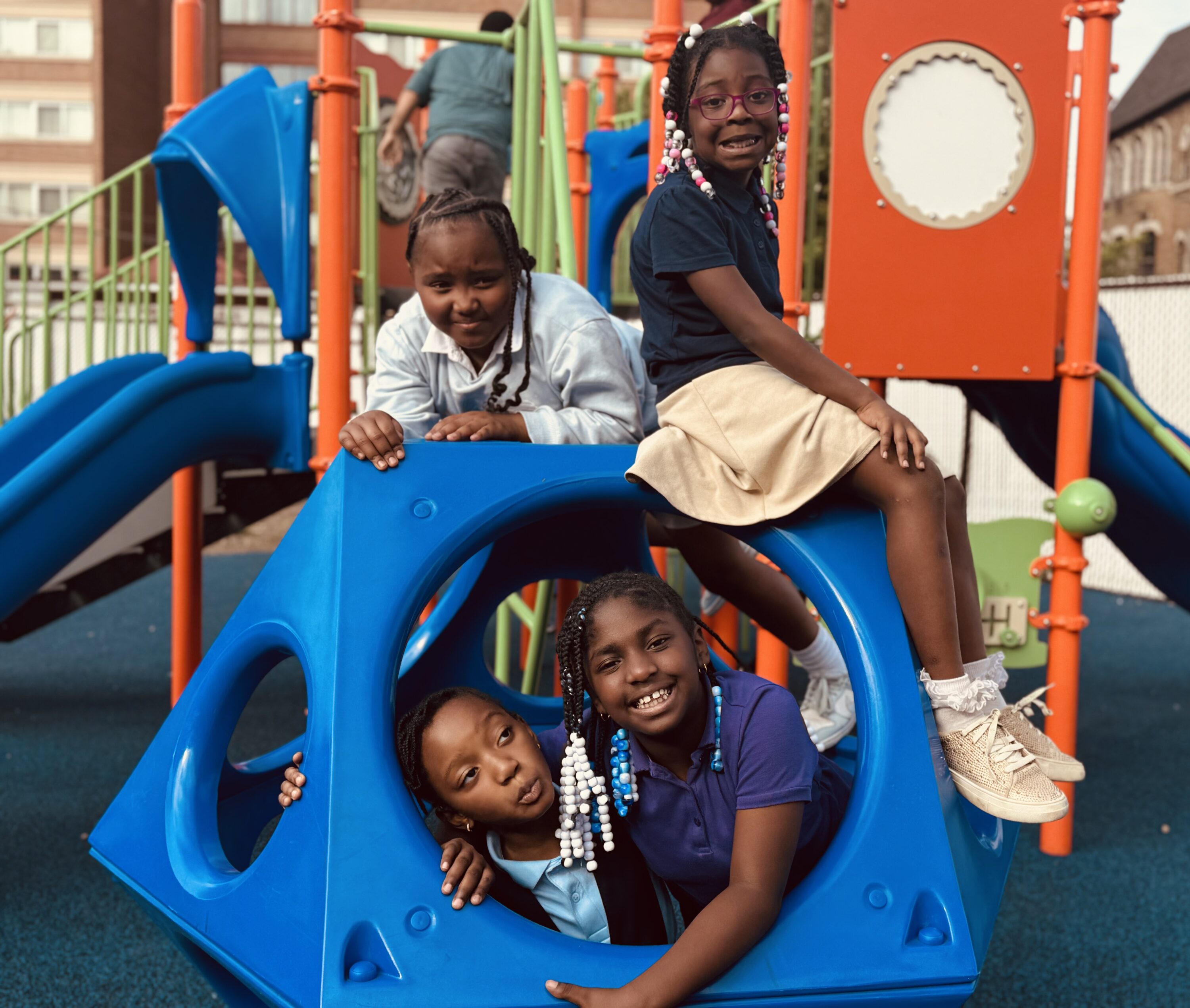 Four young children playing on a playground