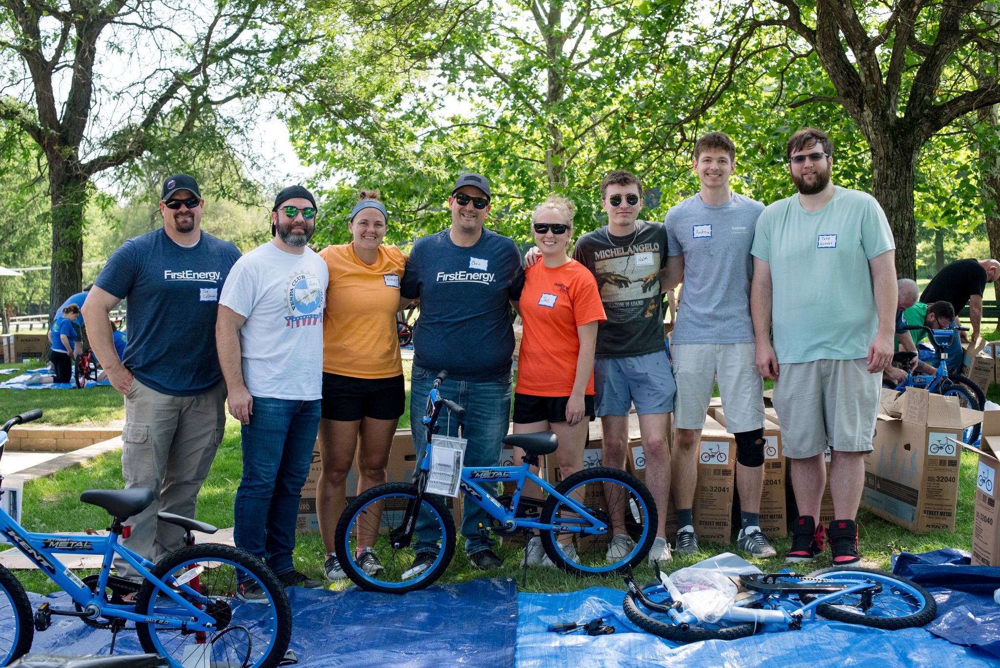 Group of men and women assembling blue bicycles