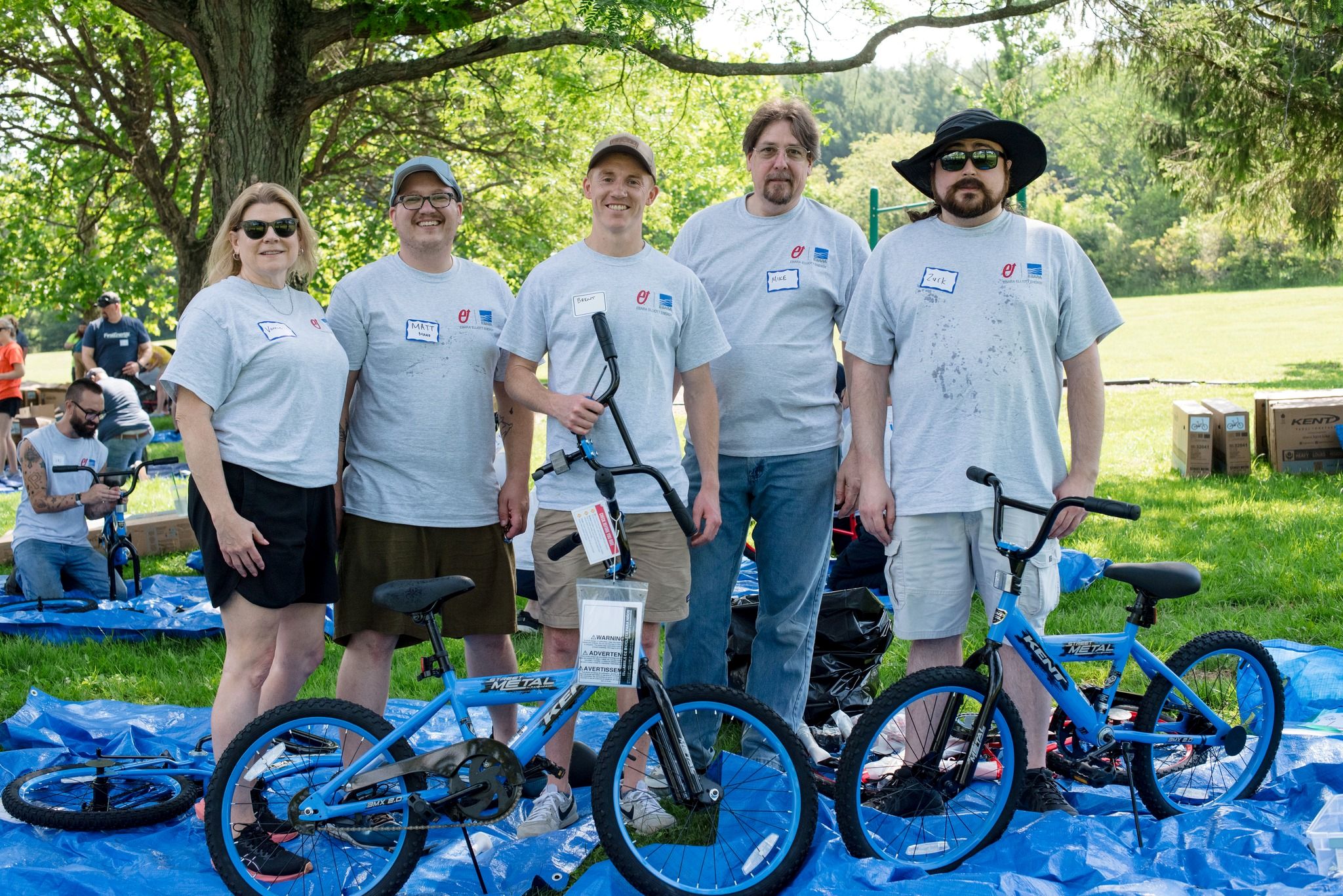 small group of men and women with two blue bicycles